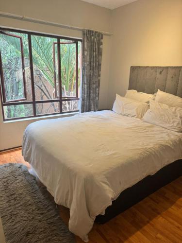 a bedroom with a large bed with a large window at The palace in Sandton