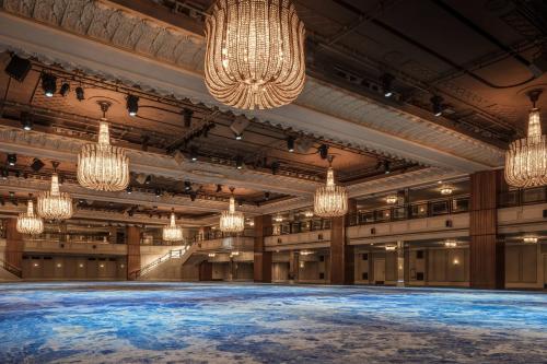 a large hall with chandeliers and a stage at JW Marriott Grosvenor House London in London