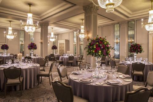 a banquet room with tables and chairs and chandeliers at JW Marriott Grosvenor House London in London