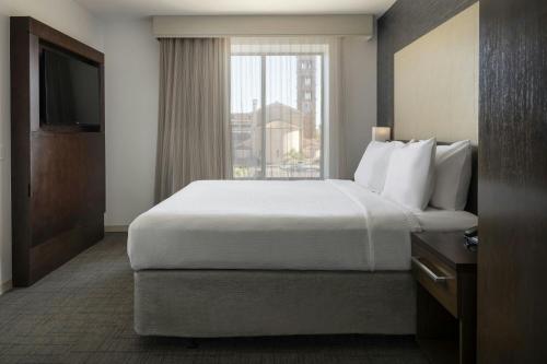 a hotel room with a large bed and a window at Residence Inn by Marriott Los Angeles Pasadena/Old Town in Pasadena
