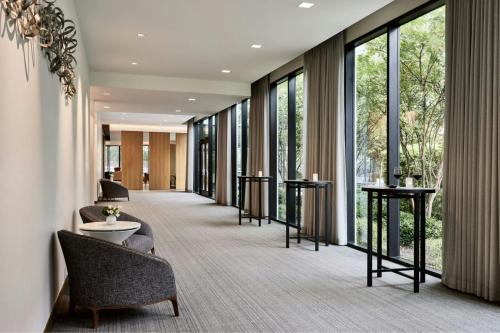 a hallway with chairs and tables and large windows at AC Hotel By Marriott Dallas By The Galleria in Dallas