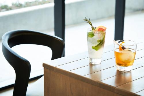 two cocktails on a wooden table with a chair at AC Hotel By Marriott Dallas By The Galleria in Dallas