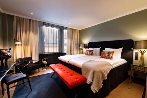 a hotel room with a large bed and a red bench at Hotel U14, Autograph Collection in Helsinki