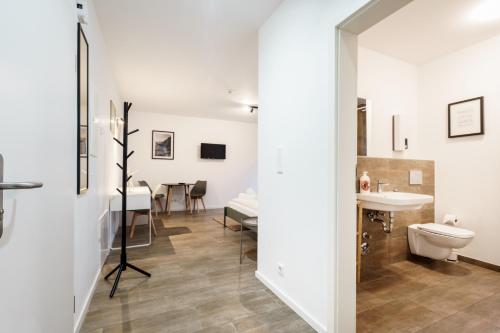 a bathroom with a sink and a toilet and a table at Greenfield I schönes OfficeStudio I W6 I Neu I Küche I Smart TV I P in Mettingen