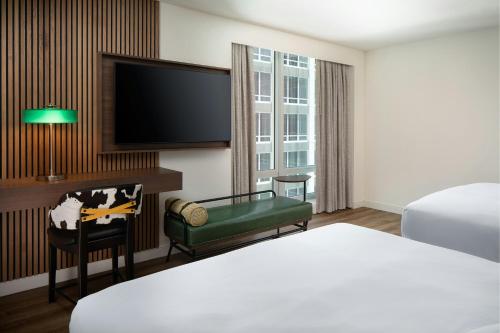 a hotel room with a bed and a flat screen tv at Le Meridien Fort Worth Downtown in Fort Worth