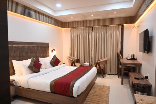 a hotel room with a bed and a desk and a desk at Hotel Sainik Grand in Varanasi
