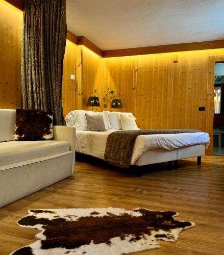 a bedroom with a large bed and a couch at Hotel Caminetto in Folgarida