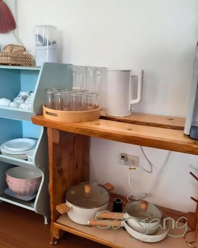 eine Küche mit Holzregalen mit Töpfen und Pfannen in der Unterkunft Sanjang Guest House in Baguio City