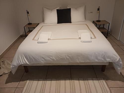 un grand lit blanc avec des draps et des oreillers blancs dans l'établissement villa with indoor pool, à Bézac