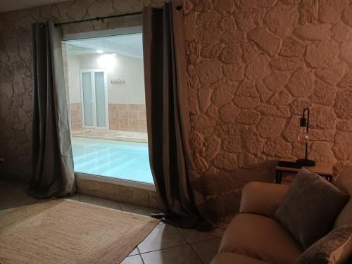 - un salon avec une fenêtre et une piscine dans l'établissement villa with indoor pool, à Bézac