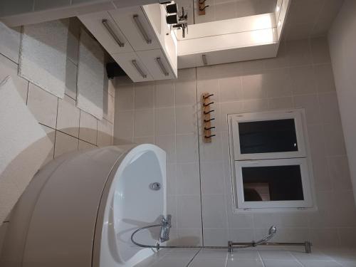 une salle de bain avec une baignoire, un lavabo et une fenêtre dans l'établissement villa with indoor pool, à Bézac