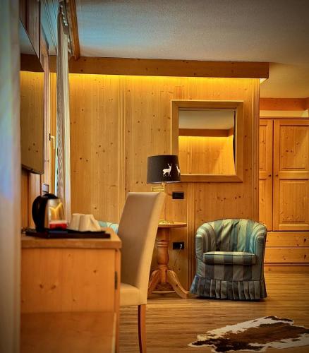 a room with a desk and a chair and a table at Hotel Caminetto in Folgarida