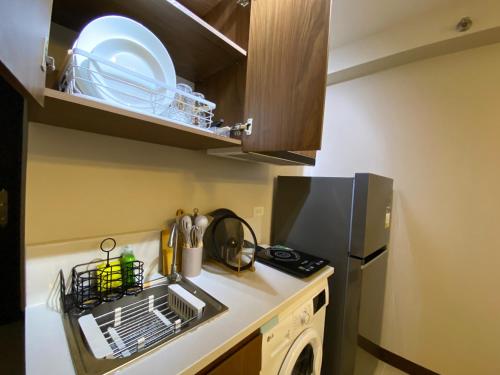 a small kitchen with a sink and a refrigerator at Z and R Haven in Lapu Lapu City