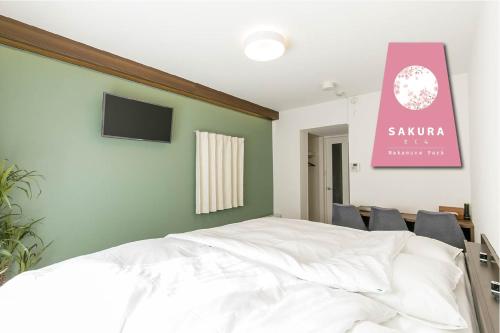 a bedroom with a white bed and a pink sign at -SAKURA- Vacation Rental in Nagoya