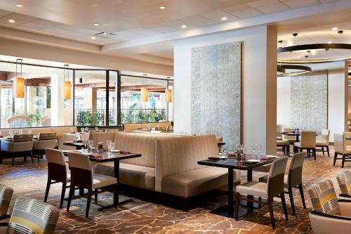 a restaurant with tables and chairs in a room at Anaheim Marriott in Anaheim