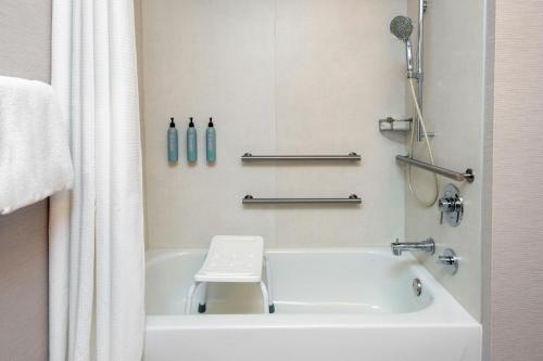 a bathroom with a white bath tub with a toilet at Courtyard by Marriott Danbury in Danbury