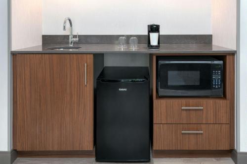 a kitchen with a black refrigerator and a microwave at Courtyard by Marriott Danbury in Danbury