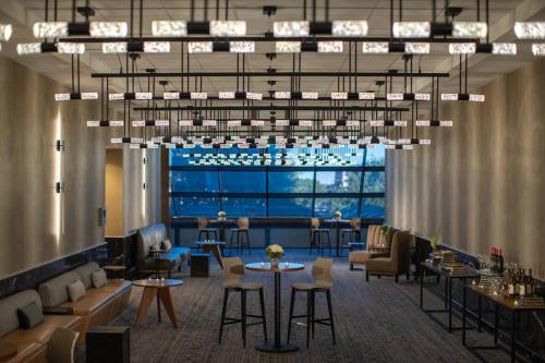 a lobby with a bar with tables and chairs at Renaissance Dallas Addison in Addison