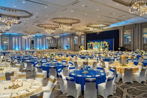 a banquet hall with tables and chairs and chandeliers at Renaissance Dallas Addison in Addison
