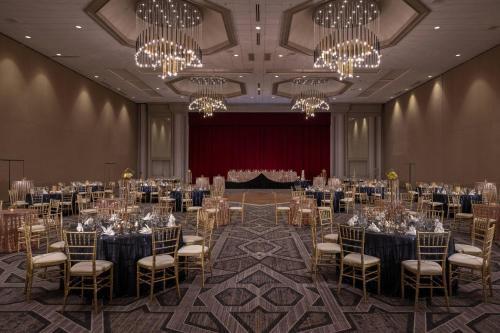 a banquet hall with tables and chairs and chandeliers at Renaissance Dallas Addison in Addison