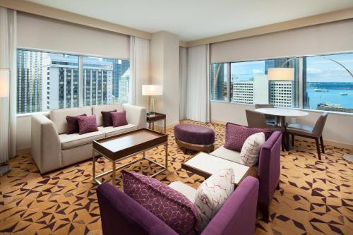 a living room with a couch and chairs and windows at Sheraton Grand Seattle in Seattle