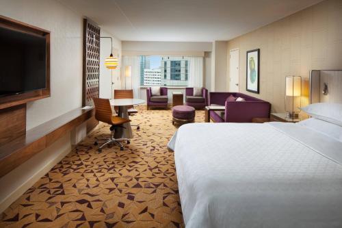 a hotel room with a bed and a table and chairs at Sheraton Grand Seattle in Seattle