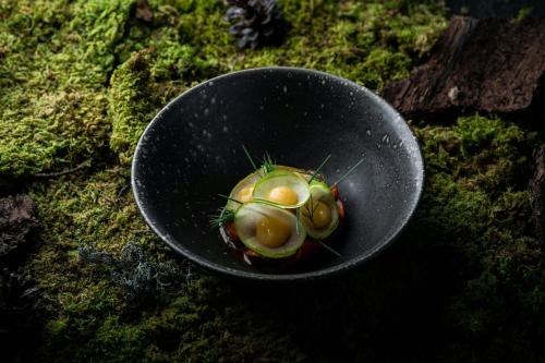 a black bowl with a green plant in it at The Ritz-Carlton Hotel de la Paix, Geneva in Geneva