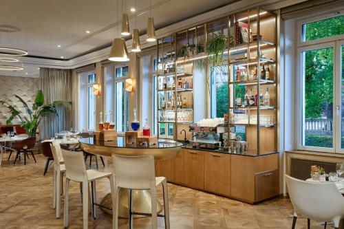 a restaurant with a table and chairs and windows at The Ritz-Carlton Hotel de la Paix, Geneva in Geneva