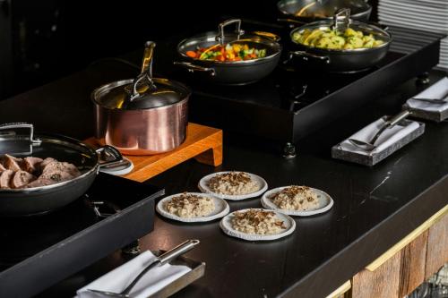 a table with plates of food and bowls of food at The Ritz-Carlton Hotel de la Paix, Geneva in Geneva