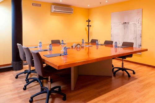 a conference room with a long wooden table and chairs at AC Hotel León San Antonio by Marriott in León