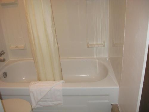 y baño con bañera blanca, aseo y lavamanos. en Pals Motel and RV Park, en Medicine Hat