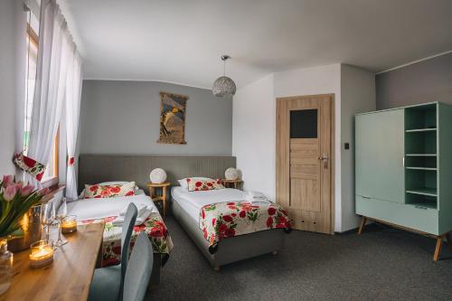 a hotel room with two beds and a table and a table sidx sidx at Karczma Taberska in Kolesin