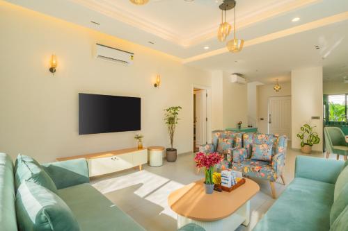TV o dispositivi per l'intrattenimento presso ELIVAAS Laguna Aurelia Luxe 4 BHK Villa Near Popular Beaches With Pool & Garden