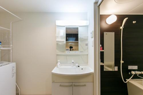 a small bathroom with a sink and a shower at -SAKURA- Vacation Rental in Nagoya