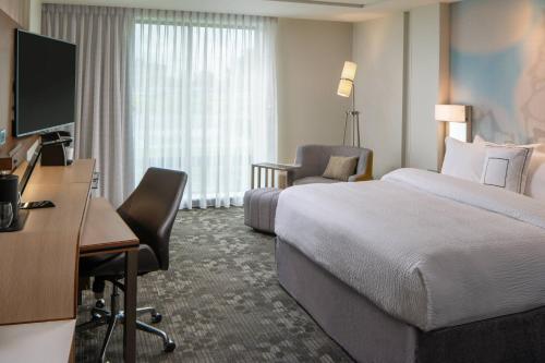 a hotel room with a bed and a desk and a computer at Courtyard by Marriott Lafayette South in Lafayette