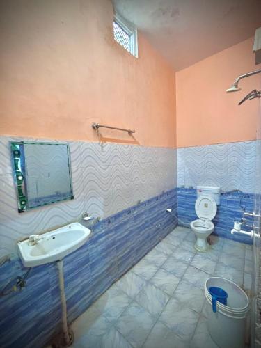 a bathroom with a sink and a toilet at Chandrakala Ashram in Naimishāranya
