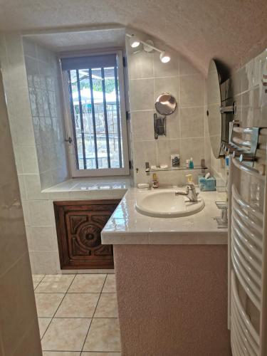 une salle de bain avec un lavabo et une fenêtre dans l'établissement Le CLOS MARFRUMA, à Montréal