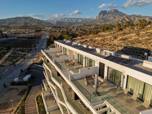 eine Luftansicht eines Gebäudes mit Bergen im Hintergrund in der Unterkunft Pure Sea Apartments Villajoyosa in Villajoyosa