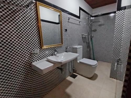 a bathroom with a sink and a shower and a toilet at Little Beach in Induruwa