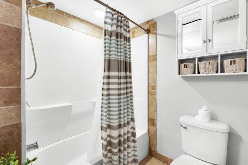 a bathroom with a shower curtain and a toilet at El Matador 513 in Fort Walton Beach