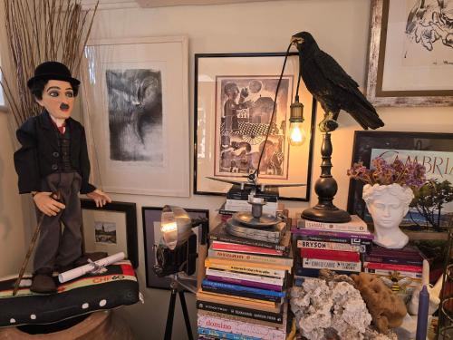 a room with a stack of books and a bird on a table at Antouanetta Apartments in Ermoupoli