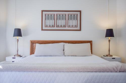 a bedroom with a white bed with two lamps at Warner Hotel in Bisbee