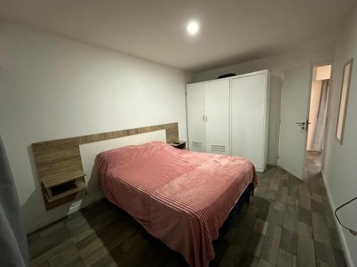 a bedroom with a bed and a white cabinet at Cabañas Diolinda in Mar del Plata