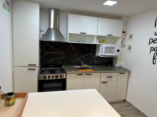 a kitchen with a stove and a microwave at Cabañas Diolinda in Mar del Plata