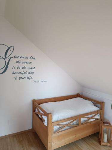 a bedroom with a bed with a quote on the wall at Ferienwohnung am Traunsee in Eck