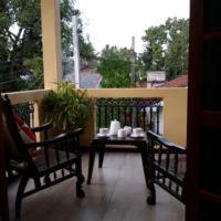 a porch with two chairs and a table on a balcony at Villa Paragon in Negombo