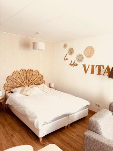a bedroom with a large white bed in a room at Casa Al Mare Studio in Zoutelande