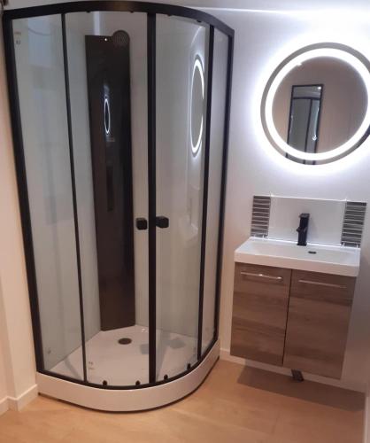 une douche en verre dans une salle de bain avec un lavabo dans l'établissement Les chambres de l'auberge, à Watten