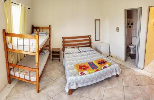 a bedroom with two bunk beds and a toilet at Pousada Aconchego in Peruíbe