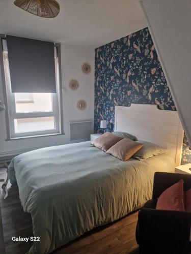 - une chambre avec un grand lit et du papier peint floral dans l'établissement Les chambres de l'auberge, à Watten